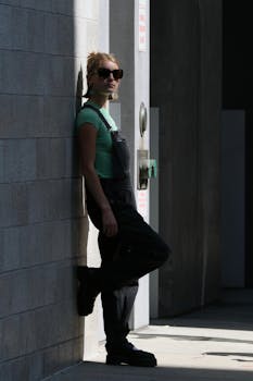 Stylish woman in sunglasses leaning against a wall in New York City, capturing urban life.